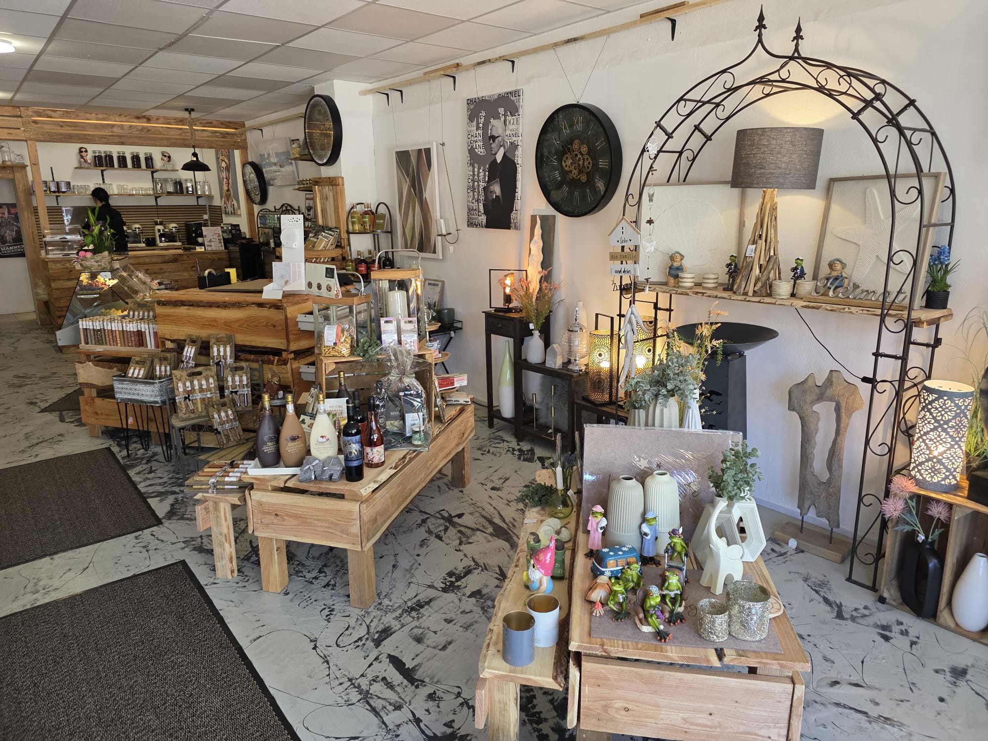 Innenraum von Genuss & Stil in Bad Bramstedt mit Holztischen, Weinen und Dekoration